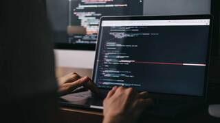 person coding on a laptop screen